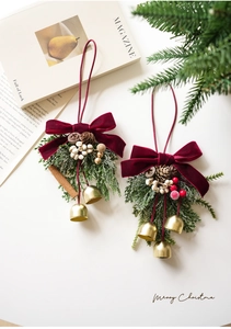 Detail of Christmas ornament with velvet bow, pine cone, gold bells and greenery