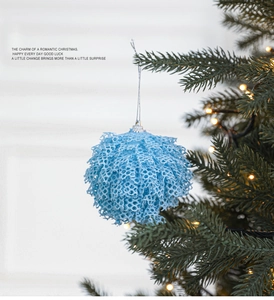 Detailed view of light blue lace texture Christmas ball ornament on tree branch