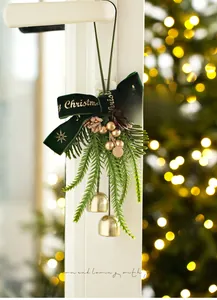 Detail of velvet Christmas bow with pine cones and golden bells on a window handle