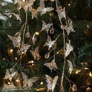 Iridescent butterfly Christmas tree pendant with crystal droplets in festive setting