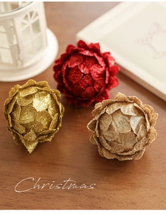 Detalle de bolas de Navidad rojas y doradas con textura floral y purpurina en madera