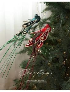 Detailed view of red and green feathered bird ornaments with gems on a Christmas tree