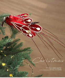Detail of red glitter Christmas bird clip with rhinestones on a festive tree branch
