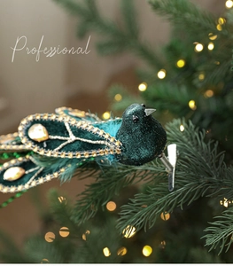 Detailed view of green glitter peacock Christmas tree ornament with metal alligator clip