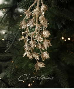 Detail eines champagnerfarbenen Glitzerzweigs mit Pailletten am Weihnachtsbaum
