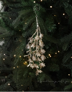Champagnerfarbener Glitzerzweig mit weißen Perlen und Haken am Weihnachtsbaum