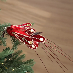 Sparkly red feathered bird ornament with gold glitter and rhinestones on a metal clip