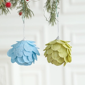 Bolas de Navidad de espuma con forma de pétalo azul y verde colgadas en el abeto