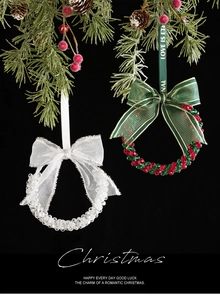 Close-up of crystal and red-green beaded Christmas ornaments on a pine branch with bows