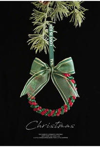 Close-up of red and green beaded Christmas wreath ornament with gold-edged ribbon bow