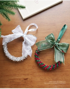 Detailed view of beaded Christmas wreaths with red green accents and ribbons