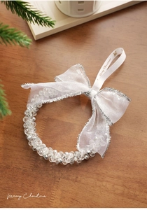 Detail of beaded Christmas wreath with ribbon bow and gold Merry Christmas text