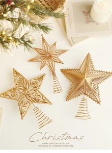 Detailed view of three golden star Christmas tree toppers with ornate metal patterns