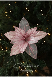 Close-up of pink glitter mesh Christmas flower on a decorated tree with warm lights