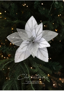 Silver hollow glitter mesh flower ornament decoration on a festive Christmas tree branch