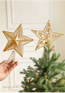 Detail of golden metal star tree topper with glittery wire pattern and spring base