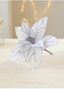 Close-up of white mesh artificial Christmas poinsettia with silver glitter for tree decor
