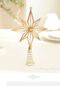 Macro view of gold metal eight-point star tree topper with a spiral spring base