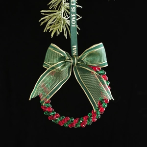 Christmas wreath ornament with red and green crystal beads and a gold ribbon bow