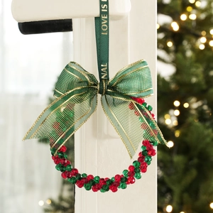 Christmas wreath ornament with red and green crystal beads and a green ribbon bow
