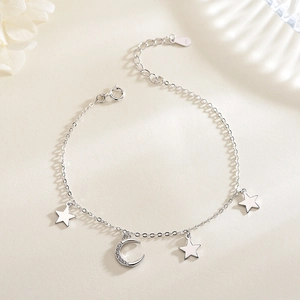 Detailed close-up of S925 sterling silver star and moon charms on a delicate link chain