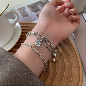 Vintage silver heart bracelet set with engraved tag and bear charm on female wrist