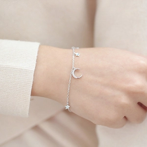Detail of S925 silver star and moon bracelet featuring sparkling zircon on model wrist