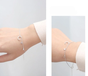 Close-up of S925 silver star and moon charms on a delicate bracelet for women