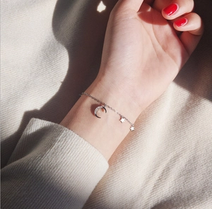 Detailed view of S925 silver star and moon bracelet with shimmering pave stones on wrist