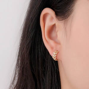 Detailed close-up of S925 silver leaf earrings with gold plating and sparkling zircon