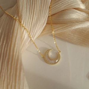 Détail du collier double couche doré avec croissant de lune serti de zircons