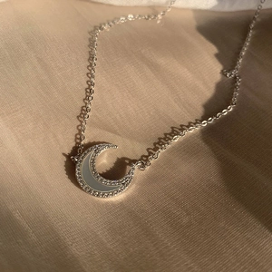 Collier lune en argent fin avec zircons et incrustation de nacre sur tissu beige clair