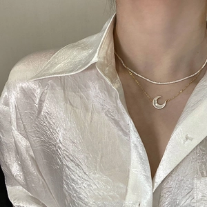 Détail d'un collier double rang avec pendentif lune en nacre et zircons sur mannequin