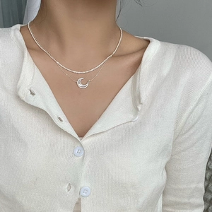 Collier double rang doré avec pendentif lune en nacre et chaîne tennis sertie de zircons