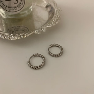 Elegant 925 sterling silver twisted hoop earrings with a textured rope design on white surface