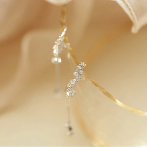 Close-up of silver drop earrings with sparkling cubic zirconia and long chain detail