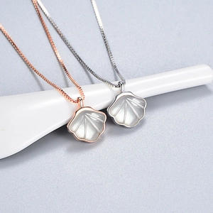 Detail showing shell-style fan pendants in rose gold and silver on slim chains
