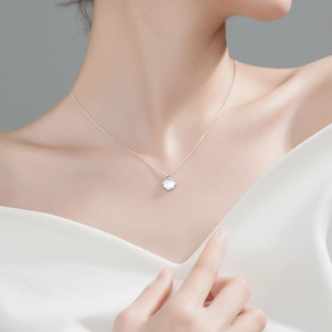 Detailed view of sterling silver shell pendant necklace worn on neck with white pearl finish