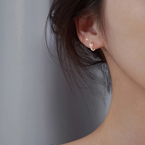 Detailed view of S925 sterling silver heart zircon hoop earring on model ear
