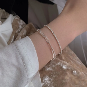 Sparkling double-layer silver star bracelet set with paperclip chain on a wrist