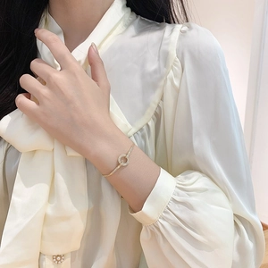 Elegante bracciale regolabile dorato con un ciondolo a cerchio traforato in zirconi lucidi