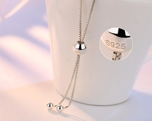 Detail of S925 sterling silver adjustable drawstring clasp with engraved hallmark beads