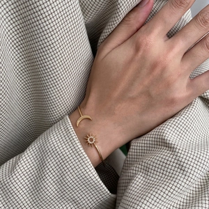 Detail of star and moon open bracelet in gold finish with sparkling zircon stones