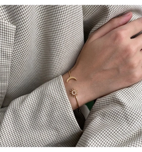Elegant gold celestial open bangle with sparkling sun and moon motifs for women