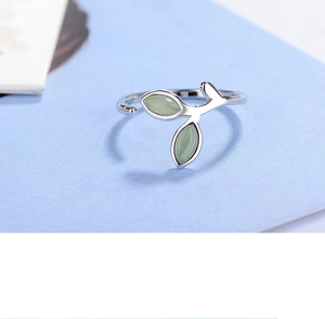 Detailed view of silver branch ring with leaf-shaped opal stones on a blue background