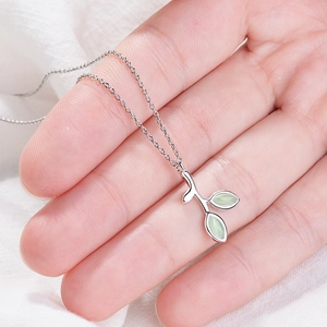 Detail of s925 silver adjustable leaf ring with light green stone in palm