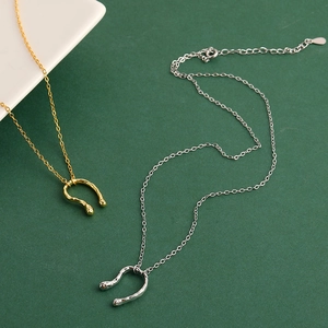 Minimalist textured U-shaped pendant necklace in gold and silver finish with elegant curves
