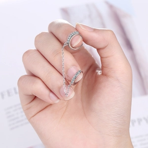 Détails des boucles d'oreilles chaîne en argent avec cristaux sur fond lavande