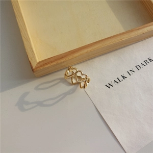 Detailed view of three hollow heart patterns on a gold minimalist open ring