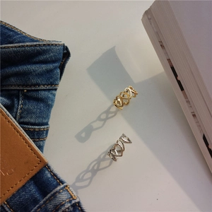 Detailed view of hollow heart rings in gold and silver reflecting heart shaped shadows